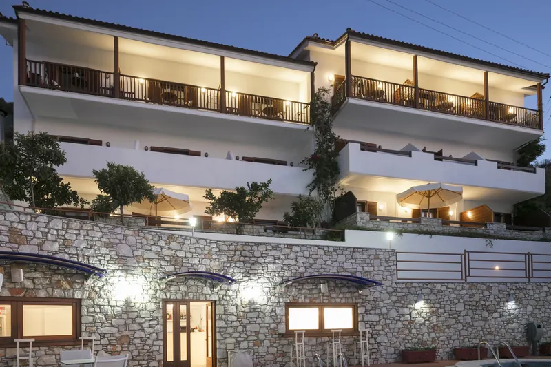 The hotel's balconies stepping up above its stone walls, lit at dusk